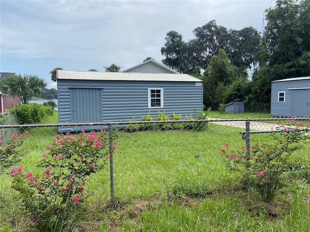view of yard with an outbuilding, a storage unit, and fence