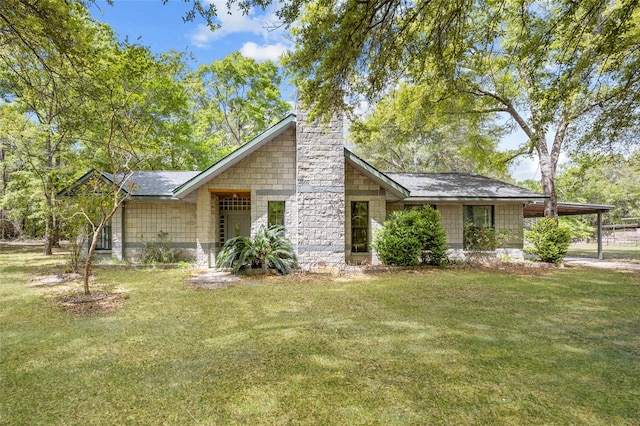 mid-century modern home with an attached carport, a chimney, and a front lawn