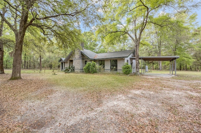 view of front facade featuring a front yard, driveway, and a chimney