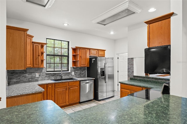 kitchen featuring backsplash, open shelves, a sink, brown cabinetry, and stainless steel appliances