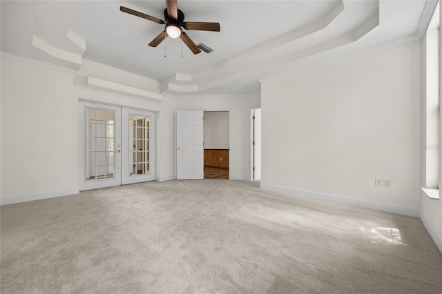 carpeted spare room featuring french doors, baseboards, a raised ceiling, visible vents, and a ceiling fan