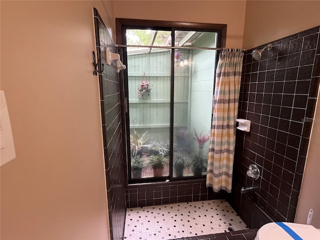 bathroom featuring toilet and a tile shower
