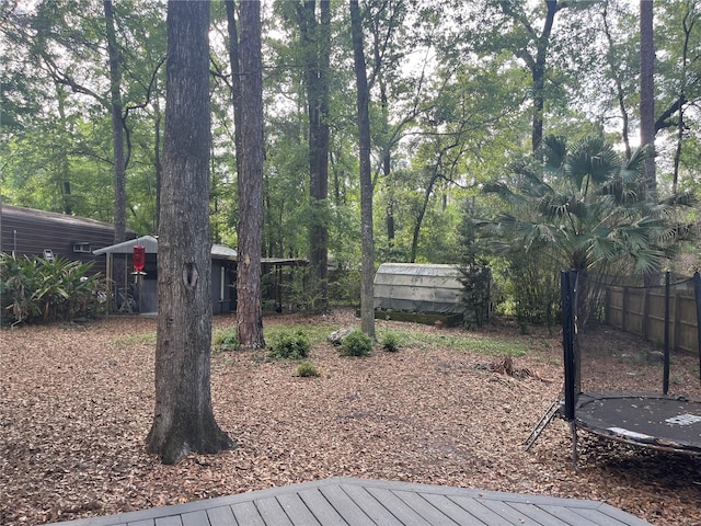 deck with a trampoline and fence