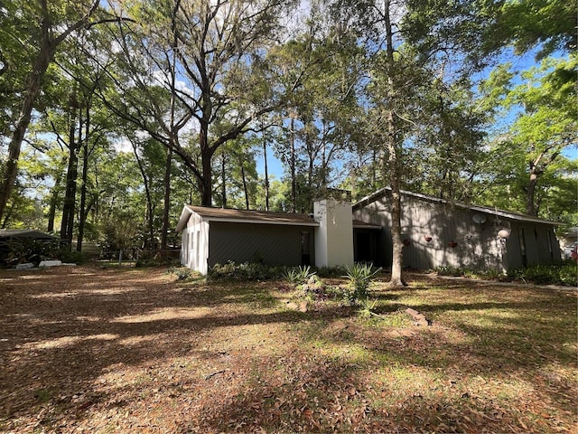 view of side of home featuring an outbuilding