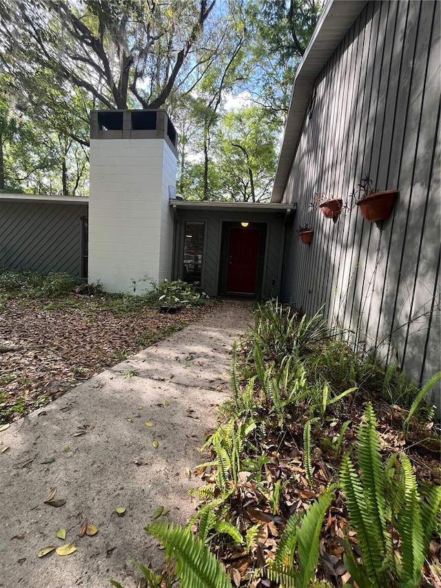 view of side of property featuring driveway and a chimney