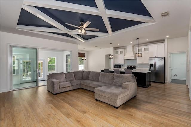 living area featuring light wood-style flooring, recessed lighting, beamed ceiling, visible vents, and coffered ceiling
