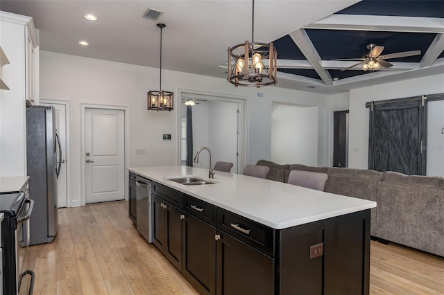 kitchen with a sink, stainless steel appliances, recessed lighting, a center island with sink, and coffered ceiling
