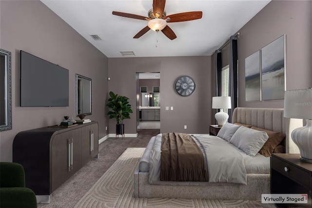 carpeted bedroom featuring ceiling fan, visible vents, baseboards, and ensuite bath