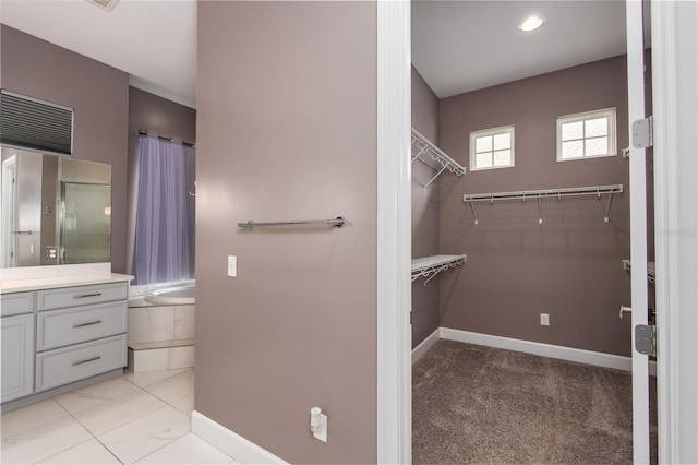 bathroom featuring vanity,  shower combination, baseboards, and a spacious closet