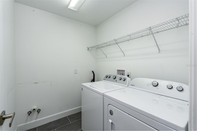 clothes washing area featuring dark tile patterned floors, baseboards, laundry area, and independent washer and dryer