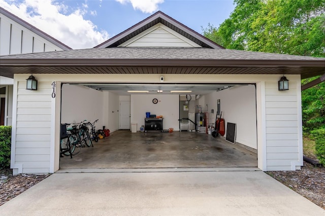 garage featuring concrete driveway and electric water heater