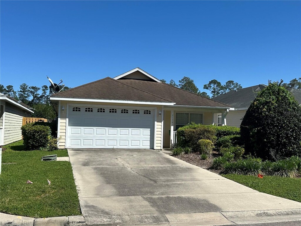 11747 NW 61st Ter, Alachua, FL 32615 - ranch-style house featuring a front yard, an attached garage, and concrete driveway