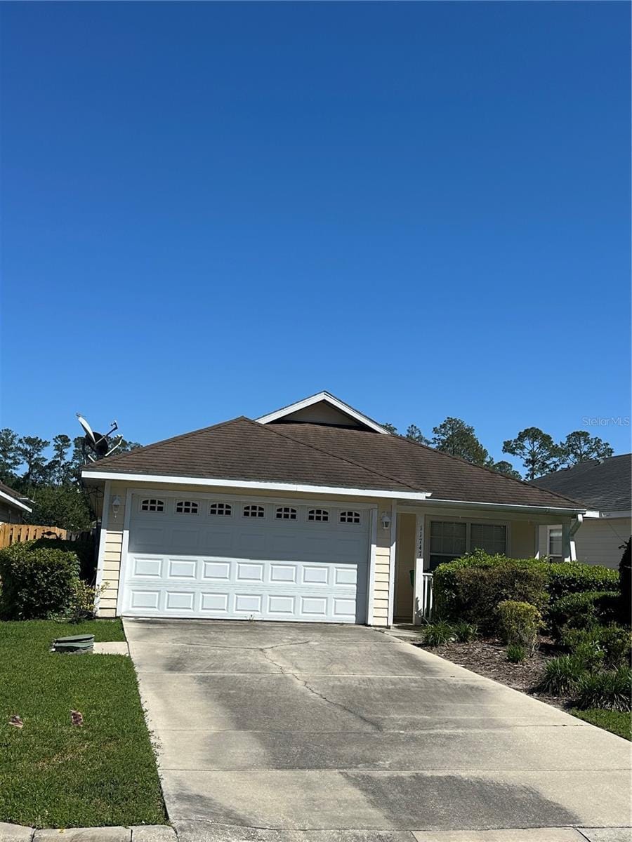 11747 NW 61st Ter, Alachua, FL 32615 - view of front of home with concrete driveway, a garage, and a front yard