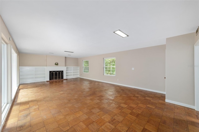 1711 NW 10th Ave, Gainesville, FL 32605 - unfurnished living room with baseboards and a fireplace with raised hearth
