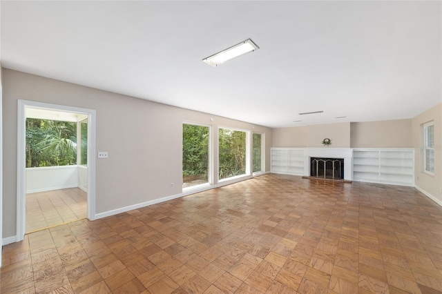 1711 NW 10th Ave, Gainesville, FL 32605 - unfurnished living room with baseboards, plenty of natural light, and a glass covered fireplace