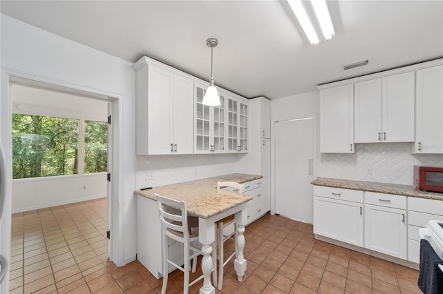 1711 NW 10th Ave, Gainesville, FL 32605 - kitchen featuring white cabinetry and light tile patterned floors