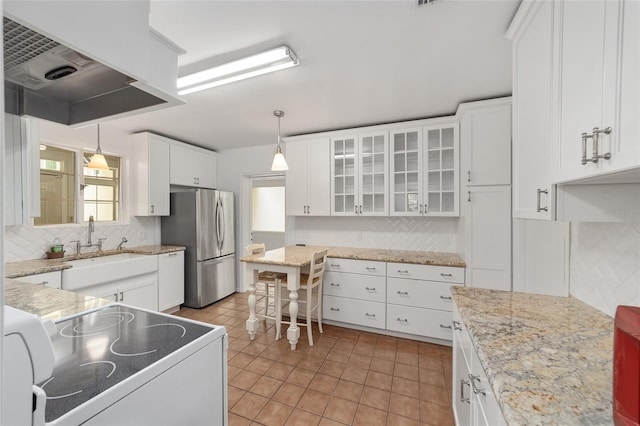 1711 NW 10th Ave, Gainesville, FL 32605 - kitchen with electric stove, tasteful backsplash, custom range hood, white cabinetry, and hanging light fixtures