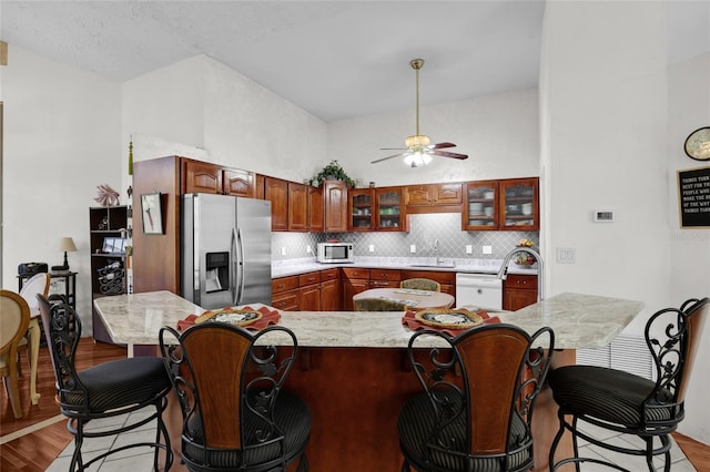 4250 NW 81st Ln, Bell, FL 32619 - kitchen with a sink, a ceiling fan, a kitchen bar, stainless steel appliances, and light wood-style flooring