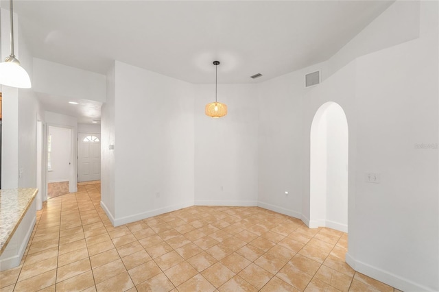 11764 NW 60th Dr, Alachua, FL 32615 - spare room featuring arched walkways, light tile patterned floors, and baseboards