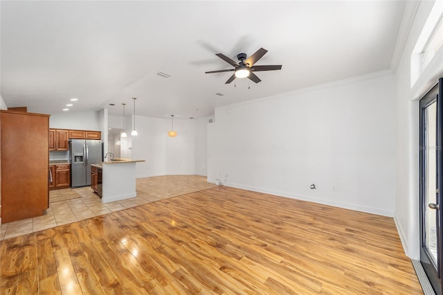 11764 NW 60th Dr, Alachua, FL 32615 - unfurnished living room featuring light wood finished floors, a ceiling fan, vaulted ceiling, a sink, and baseboards