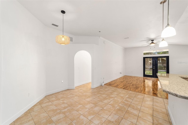 11764 NW 60th Dr, Alachua, FL 32615 - unfurnished living room with arched walkways, a ceiling fan, light tile patterned floors, french doors, and baseboards