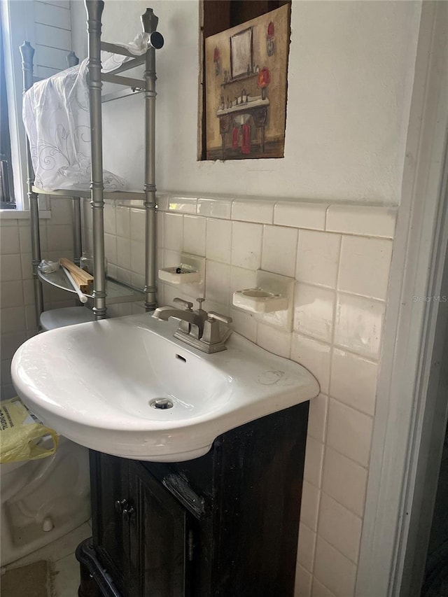 bathroom featuring vanity and tile walls