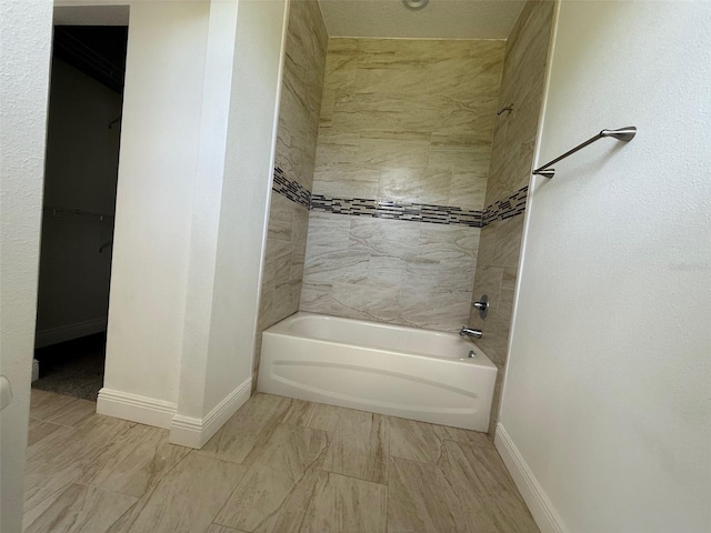 bathroom with shower / bath combination and baseboards