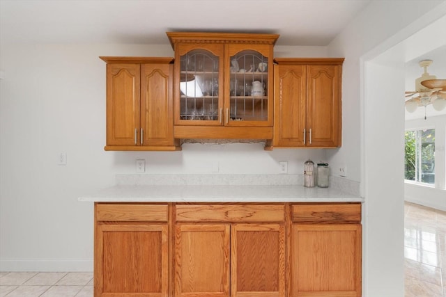 841 N Palm Springs Ter, Crystal River, FL 34429 - kitchen featuring brown cabinetry, glass insert cabinets, light countertops, and a ceiling fan