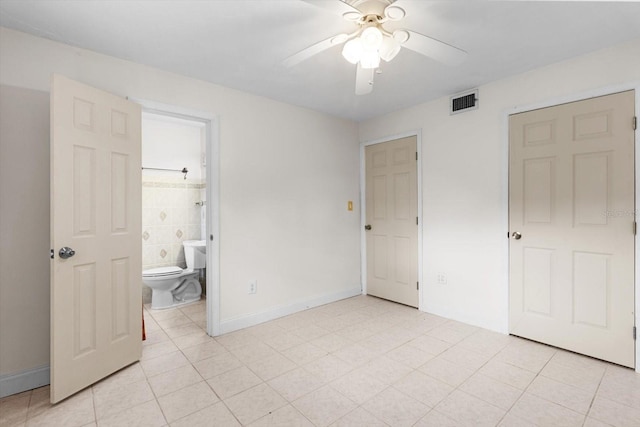 841 N Palm Springs Ter, Crystal River, FL 34429 - unfurnished bedroom featuring baseboards, light tile patterned floors, ensuite bath, visible vents, and ceiling fan