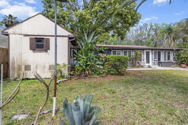 841 N Palm Springs Ter, Crystal River, FL 34429 - exterior space featuring a sunroom, a yard, fence, and an outbuilding
