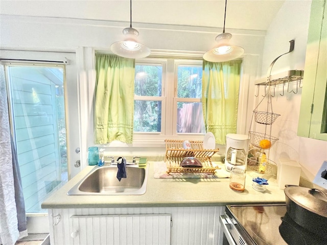 1035 NE 3rd Ave, Gainesville, FL 32601 - kitchen with a sink, range with electric cooktop, radiator heating unit, light countertops, and hanging light fixtures