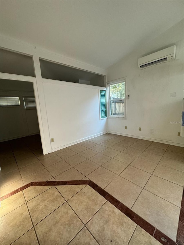 1035 NE 3rd Ave, Gainesville, FL 32601 - spare room featuring an AC wall unit, tile patterned flooring, and baseboards