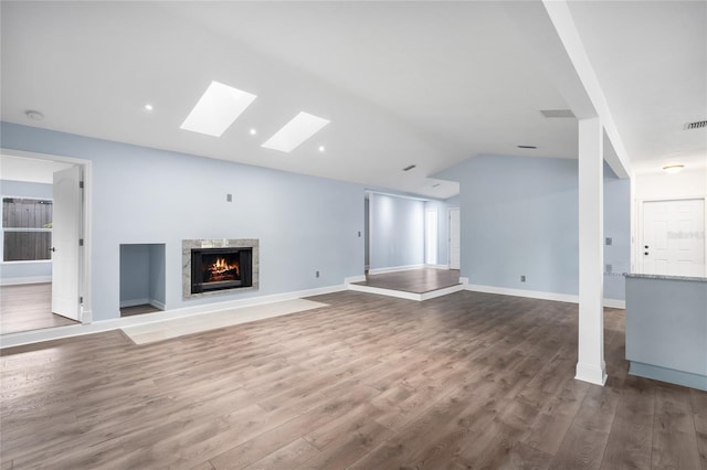 6840 NW 111th Ln, Alachua, FL 32615 - unfurnished living room with a high end fireplace, baseboards, wood finished floors, and lofted ceiling with skylight
