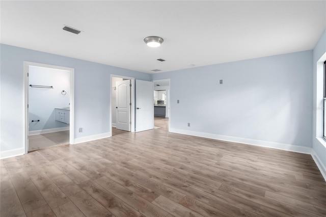 6840 NW 111th Ln, Alachua, FL 32615 - unfurnished bedroom featuring ensuite bath, visible vents, baseboards, and wood finished floors