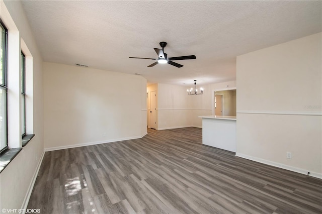 unfurnished living room featuring visible vents, baseboards, a textured ceiling, wood finished floors, and ceiling fan with notable chandelier