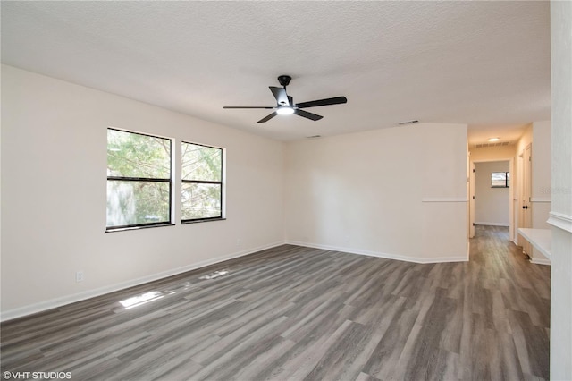 spare room featuring visible vents, baseboards, a ceiling fan, a textured ceiling, and wood finished floors