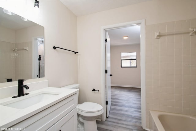 full bathroom with washtub / shower combination, baseboards, toilet, vanity, and wood finished floors