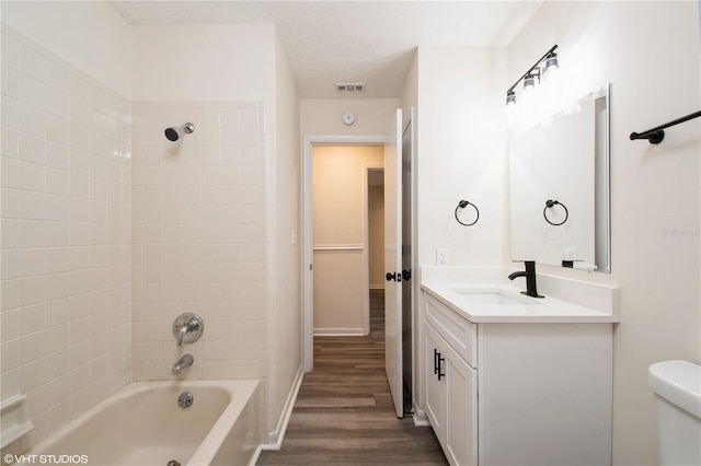 full bathroom featuring shower / washtub combination, vanity, toilet, wood finished floors, and baseboards