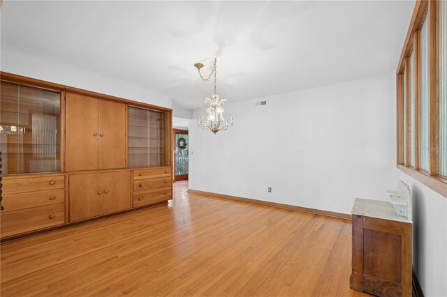 2210 NW 6th Pl, Gainesville, FL 32603 - unfurnished dining area featuring light wood finished floors, a chandelier, and baseboards