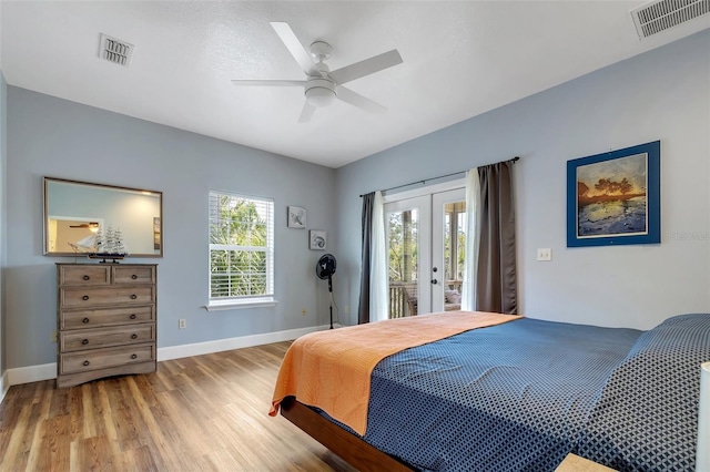 bedroom featuring access to outside, visible vents, wood finished floors, french doors, and baseboards