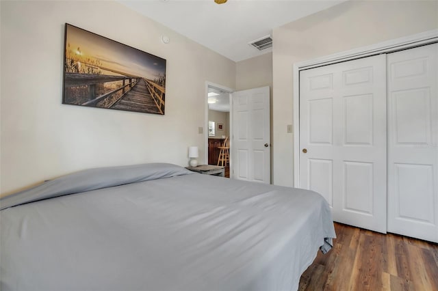 bedroom with visible vents, a closet, and dark wood-style floors