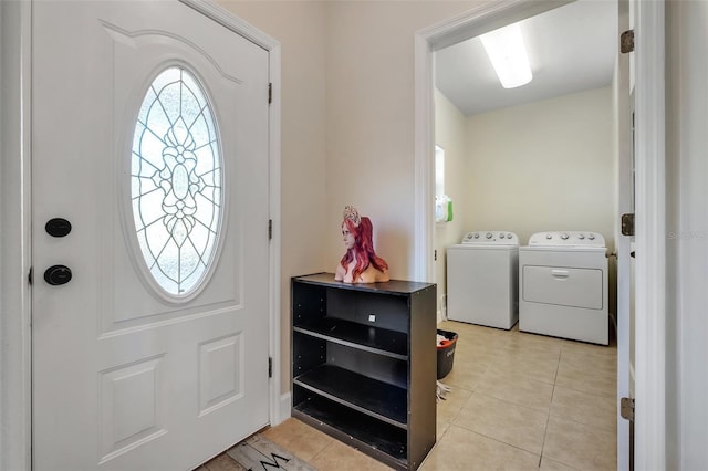 foyer entrance with light tile patterned floors and washing machine and dryer