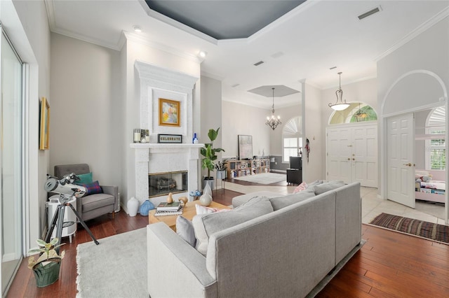 3802 SW 93rd Ter, Gainesville, FL 32608 - living area with hardwood / wood-style floors, ornamental molding, a fireplace, a raised ceiling, and a chandelier