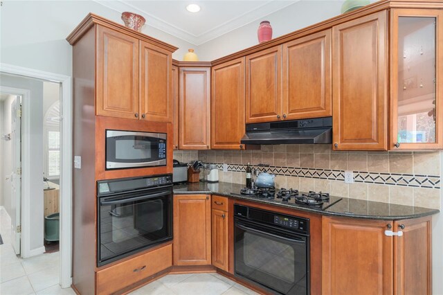 3802 SW 93rd Ter, Gainesville, FL 32608 - kitchen featuring black appliances, under cabinet range hood, dark stone countertops, light tile patterned floors, and backsplash