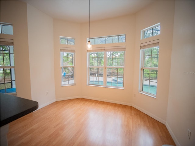 unfurnished dining area with light wood finished floors and baseboards