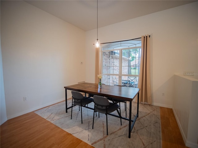 dining space with light wood-style flooring and baseboards