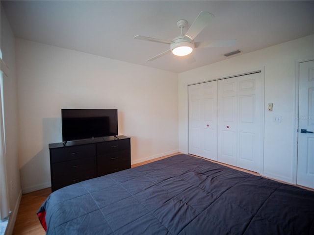 bedroom featuring visible vents, baseboards, a ceiling fan, and wood finished floors