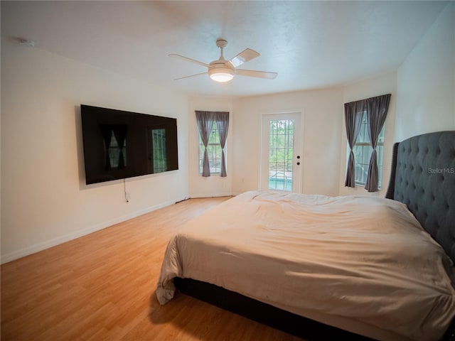 bedroom featuring baseboards, access to outside, ceiling fan, and wood finished floors