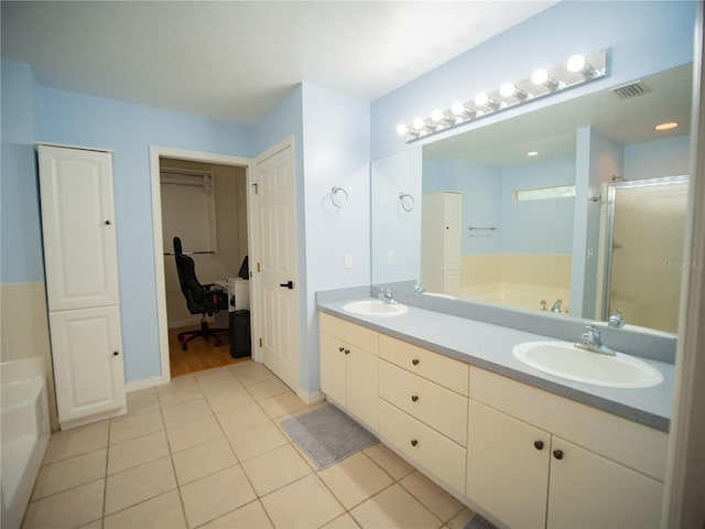 bathroom with a sink, a bath, tile patterned flooring, and a stall shower