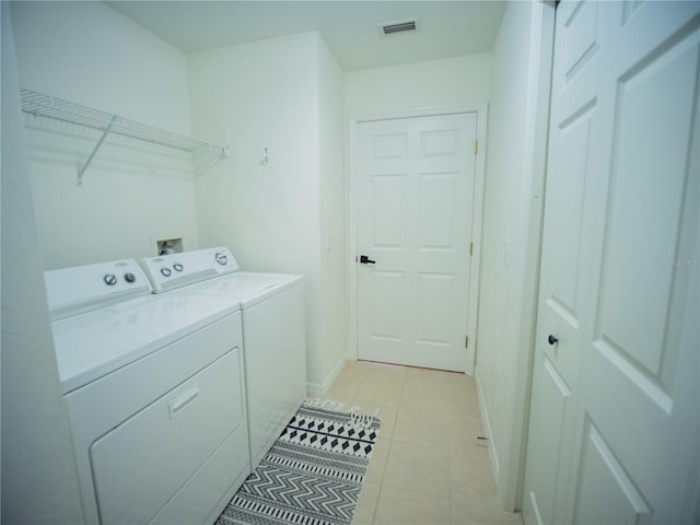 laundry area with washer and clothes dryer, visible vents, laundry area, and baseboards